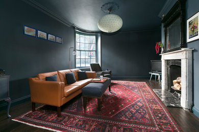 Foto di un soggiorno industriale con pareti grigie e camino classico