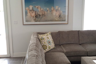 Geräumiges, Offenes Klassisches Wohnzimmer mit grauer Wandfarbe, Betonboden, Kamin, Kaminumrandung aus Stein und TV-Wand in Toronto