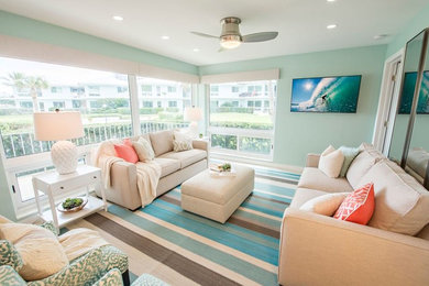 Imagen de salón para visitas abierto costero grande con paredes azules, suelo de madera clara y suelo beige