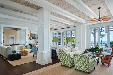 Photo of a beach style living room in Miami with white walls and brown floors.