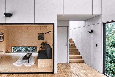 Medium sized contemporary open plan living room in Sunshine Coast with medium hardwood flooring and a freestanding tv.