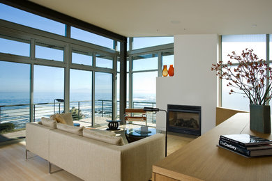 Example of a mid-sized minimalist open concept bamboo floor living room design in San Francisco with white walls, a standard fireplace, a plaster fireplace and a concealed tv