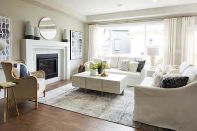 Example of a transitional formal and enclosed medium tone wood floor and brown floor living room design in Edmonton with beige walls, a standard fireplace and no tv
