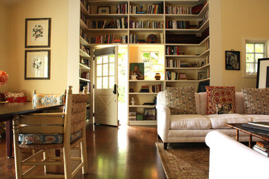 Cette photo montre un salon nature avec une bibliothèque ou un coin lecture et un mur jaune.