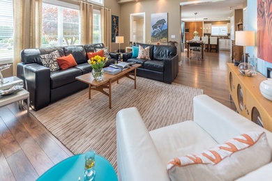 Living room - large contemporary open concept laminate floor and brown floor living room idea in Vancouver with beige walls, a wood stove, a tile fireplace and a wall-mounted tv