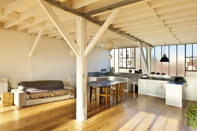 Diseño de salón para visitas abierto urbano de tamaño medio con paredes blancas y suelo de madera clara