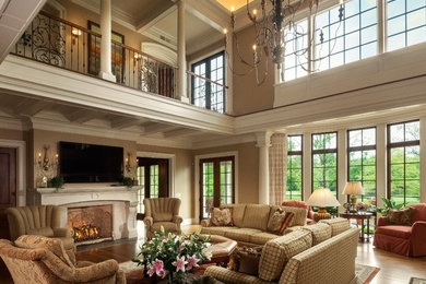 Expansive mediterranean open plan living room in Columbus with beige walls, medium hardwood flooring, a standard fireplace, a stone fireplace surround, a wall mounted tv and brown floors.