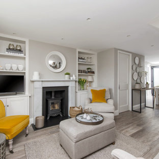 Design ideas for a large classic open plan living room in London with grey walls, a wood burning stove, a metal fireplace surround, a freestanding tv and grey floors.