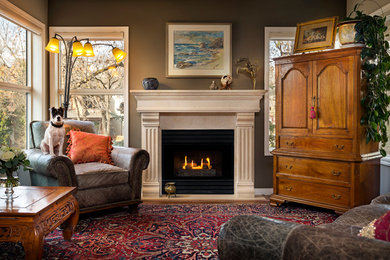 Example of a mid-sized classic open concept medium tone wood floor living room design in Vancouver with gray walls, a standard fireplace and a concealed tv