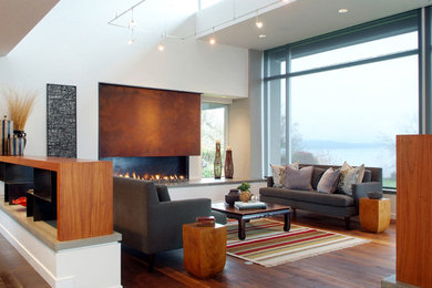 Large trendy open concept medium tone wood floor living room photo in Seattle with a ribbon fireplace, a metal fireplace and white walls