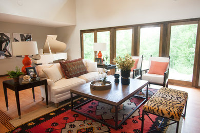 Aménagement d'un salon contemporain de taille moyenne et ouvert avec un mur orange, un sol en bois brun, une cheminée double-face et un manteau de cheminée en pierre.