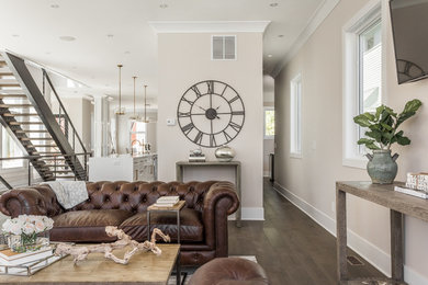Geräumiges, Offenes Klassisches Wohnzimmer mit beiger Wandfarbe, dunklem Holzboden, TV-Wand und braunem Boden in Indianapolis