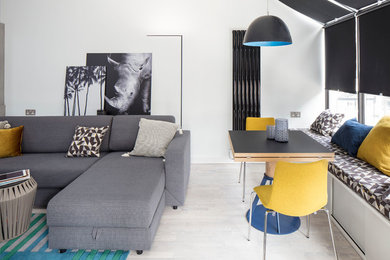 Foto di un soggiorno minimal di medie dimensioni e aperto con libreria, pareti bianche, parquet chiaro, TV a parete e pavimento grigio