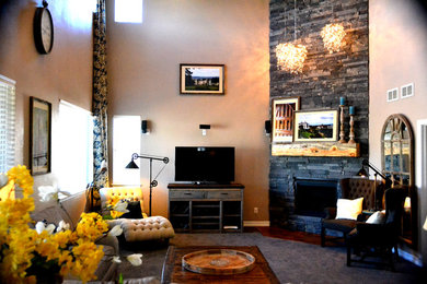Diseño de salón abierto campestre grande con paredes beige, chimenea de esquina, marco de chimenea de piedra y televisor independiente