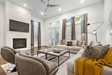 Example of a transitional dark wood floor and brown floor living room design in Houston with white walls, a wall-mounted tv and a stone fireplace