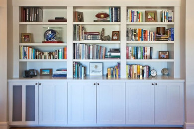 Foto de biblioteca en casa abierta actual de tamaño medio con paredes beige y suelo de madera en tonos medios
