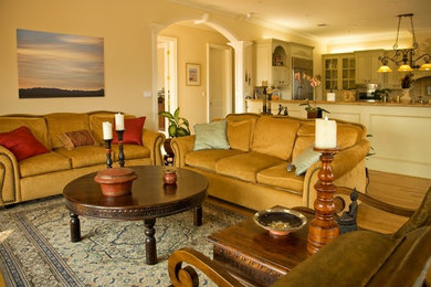 Imagen de salón para visitas cerrado tradicional renovado de tamaño medio sin chimenea y televisor con paredes beige, suelo de madera clara y suelo marrón