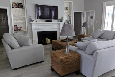 Inspiration for a mid-sized transitional formal gray floor living room remodel in Houston with gray walls, a standard fireplace, a plaster fireplace and a wall-mounted tv