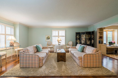 This is an example of a large classic formal enclosed living room in Other with blue walls, medium hardwood flooring, no fireplace, no tv and beige floors.