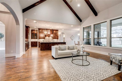 Fernseherloses Modernes Wohnzimmer mit weißer Wandfarbe, braunem Holzboden, Kamin, Kaminumrandung aus Stein und braunem Boden in Dallas