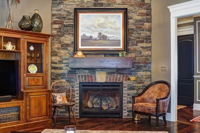 Cette photo montre un salon chic de taille moyenne et fermé avec une salle de réception, un mur beige, parquet foncé, une cheminée d'angle, un manteau de cheminée en pierre et un téléviseur indépendant.