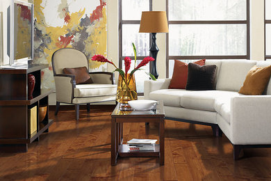 Cette image montre un grand salon avec un mur beige et un sol en bois brun.