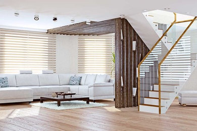 Imagen de salón para visitas abierto actual grande sin chimenea y televisor con paredes blancas, suelo de madera clara y suelo beige