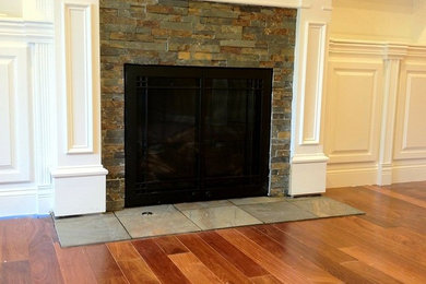 Mid-sized medium tone wood floor living room photo in New York with white walls, a standard fireplace and a stone fireplace