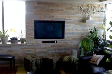 Large medium tone wood floor living room photo in New York with beige walls and a media wall