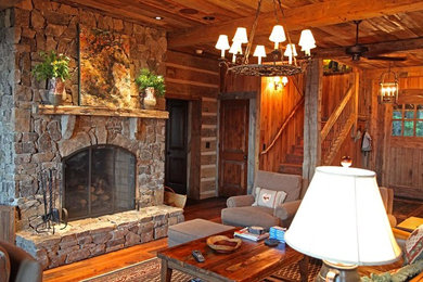 Foto de salón de estilo americano de tamaño medio sin televisor con paredes marrones, suelo de madera en tonos medios, todas las chimeneas y marco de chimenea de piedra