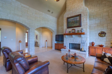 Large elegant formal and enclosed carpeted living room photo in Austin with beige walls, a standard fireplace, a stone fireplace and a tv stand