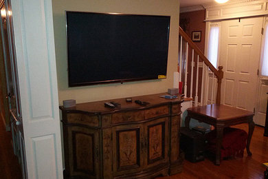 Inspiration for a medium tone wood floor living room remodel in Providence with a wall-mounted tv