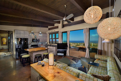 Modelo de salón para visitas abierto tropical grande con paredes blancas, suelo de madera en tonos medios y televisor independiente