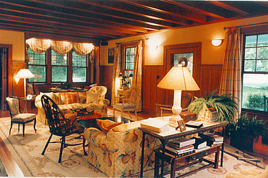 Modelo de salón abierto actual de tamaño medio con paredes beige, suelo de madera clara, todas las chimeneas, marco de chimenea de metal y suelo negro
