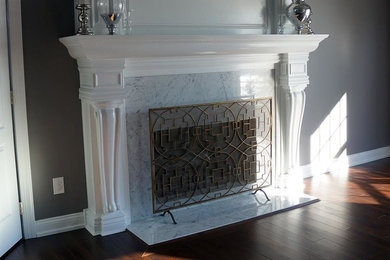 フィラデルフィアにある中くらいなトラディショナルスタイルのおしゃれなリビング (グレーの壁、濃色無垢フローリング、標準型暖炉、石材の暖炉まわり、茶色い床) の写真