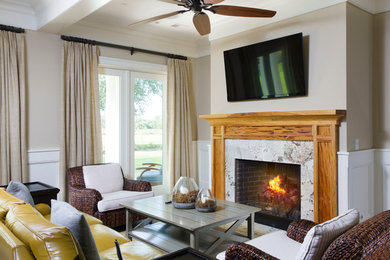 Example of a mid-sized island style formal and open concept dark wood floor and brown floor living room design in Charleston with beige walls, a standard fireplace, a stone fireplace and a wall-mounted tv