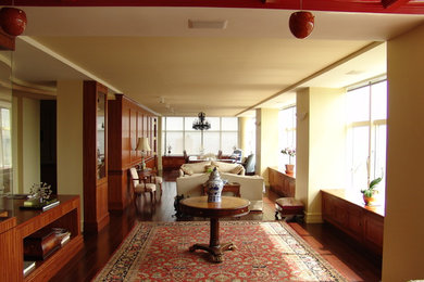 Example of a mid-sized transitional open concept dark wood floor and brown floor living room design in New York with beige walls and no fireplace