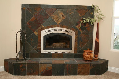 他の地域にあるトラディショナルスタイルのおしゃれなリビング (標準型暖炉、石材の暖炉まわり) の写真