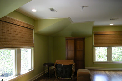 Diseño de salón grande con paredes verdes y suelo de madera en tonos medios