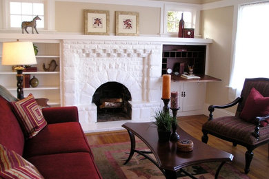 This is an example of a small classic formal enclosed living room in San Francisco with beige walls, light hardwood flooring, a standard fireplace, a brick fireplace surround and no tv.