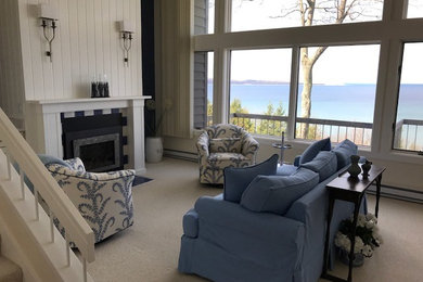 Example of a mid-sized beach style formal and open concept carpeted and brown floor living room design in Other with beige walls, a standard fireplace, a wood fireplace surround and no tv