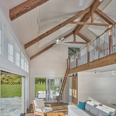 Inspiration for a country loft-style brown floor and medium tone wood floor living room remodel in DC Metro with beige walls