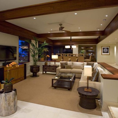 Example of an island style living room design in Hawaii with beige walls and a tv stand