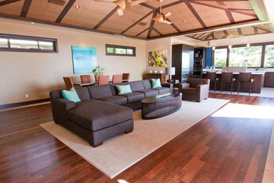 Inspiration for a large tropical formal and open concept dark wood floor and brown floor living room remodel in Portland with beige walls, no fireplace and a wall-mounted tv