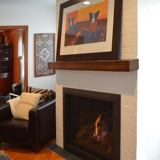 Example of an eclectic living room design in New York with white walls, a standard fireplace and a brick fireplace