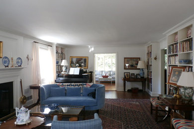 На фото: большая гостиная комната в классическом стиле с с книжными шкафами и полками и белыми стенами