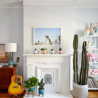 Großes, Fernseherloses, Abgetrenntes Stilmix Wohnzimmer mit Hausbar, blauer Wandfarbe, Kamin, braunem Boden und braunem Holzboden in New York