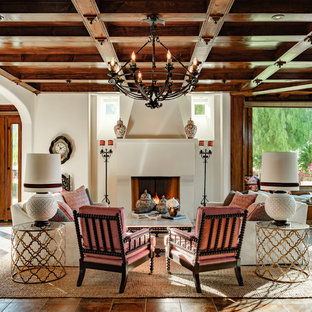 Mediterranes Wohnzimmer mit weißer Wandfarbe, Kamin und braunem Boden in Los Angeles