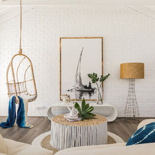 Beach style living room in Perth with white walls, medium hardwood floors and brown floor.