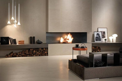 Aménagement d'un grand salon moderne ouvert avec un mur gris, sol en béton ciré, une cheminée ribbon, un manteau de cheminée en carrelage et un sol gris.